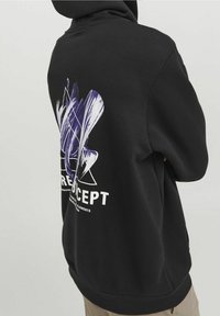 Felpa nera con cappuccio caratterizzata da un ampio design astratto in viola e bianco sul retro, con la parola "CONCEPT" stampata in bianco sotto.