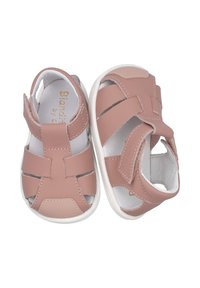 Sandalias de cuero rosa para toddlers con punta cerrada y diseño de múltiples correas. Suela de goma blanca y forro interior. Cuenta con cierre de Velcro para facilitar su uso.