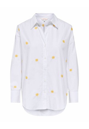 Chemise blanche à manches longues avec col pointu et petits motifs jaunes en forme de soleil dispersés sur le devant et les manches.