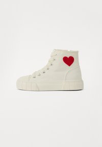 Hög-top sneakers i off-white canvas med röd hjärtbroderi på sidan. Funktioner inkluderar rund tå, gummisula och metallöglor för snörning.