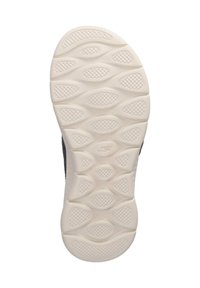 Sole of sneaker with a textured white rubber surface featuring wavy patterns and oval indentations for grip and traction.