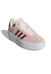 Sneaker in suede rosa con strisce rosso scuro, suola bianca piatta e design con lacci. Presenta un collare imbottito per il comfort.