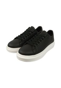 Sneakers sintetici neri con texture liscia, punta rotonda e suola in gomma bianca. Caratterizzati da lacci neri e dettaglio del logo sul lato.