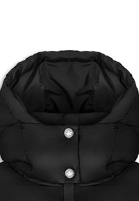 Černý pufový kabát s límcem s prošívanou texturou, patentkami a hladkou vnitřní podšívkou. Výrazné stříbrné logo akcenty.