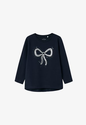 Camiseta de manga larga azul marino con diseño de lazo de purpurina plateada rodeado de pequeños destellos en el frente, cuello redondo y corte básico.