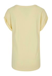 Gul kortærmet t-shirt med rund halsudskæring, blødt bomuldsstof, løs pasform og oprullede ærmer. Enkelt, uden mønstre eller detaljer.