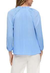 Lichtblauwe geplooide blouse met lange mouwen, verzamelde halslijn en elastische manchetten, gemaakt van gladde stof met een vloeiende drapering.