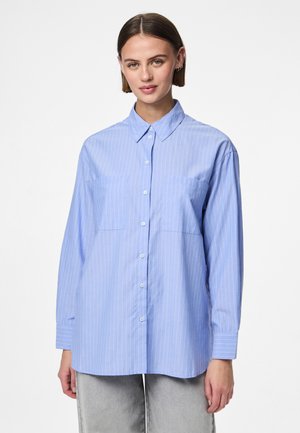 Svetlo modra srajca z gumbi s črtami, dolgimi rokavi, ostrim ovratnikom, dvema prsima žepoma in sproščenim krojem. Bombažni material z gladko teksturo.
