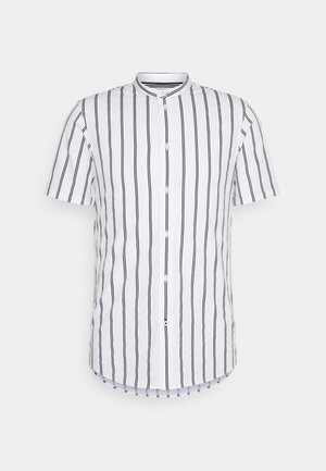 Chemise à manches courtes en tissu blanc avec des rayures verticales noires, dotée d'un col droit et d'une fermeture à boutons sur le devant.