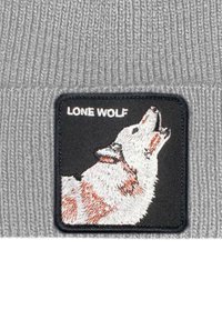 Berretto a maglia grigio con un patch nero raffigurante un lupo ululante in ricamo bianco e arancione, con il testo "LONE WOLF" sopra.