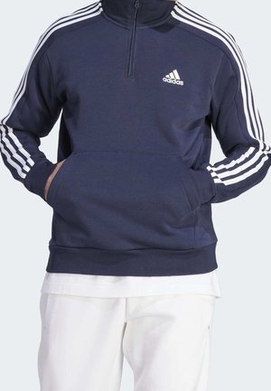 Sudadera con cremallera en color azul marino con acentos de tres rayas blancas en las mangas, que cuenta con un bolsillo frontal y un pequeño logo en el pecho.