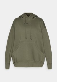 Sudadera oversized de color verde oliva hecha de tela suave. Cuenta con un bolsillo frontal, cordones y texto impreso en negro "PARÍS" junto con el logo de Nike.