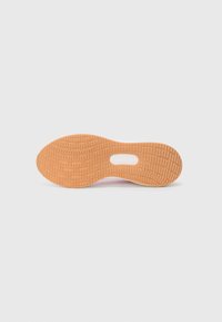 Semelle extérieure de chaussure en caoutchouc texturé orange avec un motif de bande de roulement distinctif et une découpe circulaire au centre.