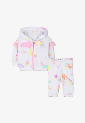 Veste blanche à capuche avec des accents de volants roses et des motifs colorés et ludiques, associée à des leggings assortis présentant des designs similaires.