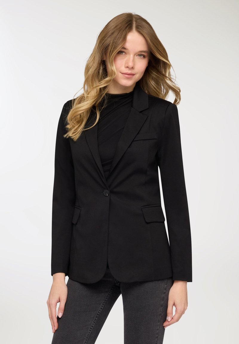 Blazer nero con design sartoriale, due tasche anteriori e chiusura con un solo bottone. Tessuto liscio e maniche lunghe.