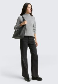 Gray ribbed sweater with a high neckline, paired with black wide-leg jeans and black chunky boots. Large black tote bag.