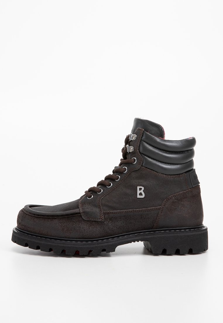 Braune Wildlederstiefel mit einem schwarzen Lederkragen, runder Zehenkappe, schnürbarem Vorderteil und robuster, strukturiertem Sohlenprofil. Mit einem metallischen Logo-Akzent.