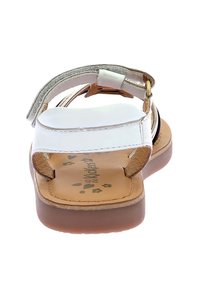 Sandalia blanca de espalda abierta con suela marrón. Cuenta con una plantilla acolchada, correa ajustable y acentos metálicos. Tirante superior texturizado.