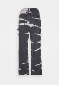 Los pantalones cargo grises presentan un patrón de tie-dye en blanco y negro, con bolsillos a ambos lados y un corte relajado. Tejido de algodón texturizado.