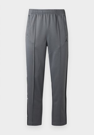 Gray athletic pants with elastic waistband, side pockets, black side panels, and a small black Jumpman logo on the right thigh.