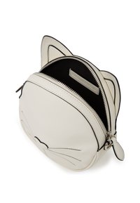 Sac en cuir couleur crème en forme de tête de chat, avec des coutures noires, des détails de moustaches et un compartiment zippé avec un intérieur noir.