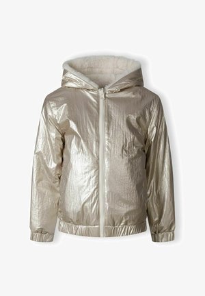 Veste mi-longue en métal doré avec capuche, doublure en fausse fourrure blanche, et ourlet et poignets élastiqués. Fermeture éclair frontale visible.