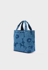 Μικρή μπλε τσάντα ώμου με μεγάλα λουλουδένια μοτίβα και δύο κοντά χερούλια, τοποθετημένη σε απλό φωτεινό φόντο.