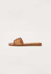 Sandały na slip-on s hnědou koženou podrážkou, tkaným páskem a texturovaným detailem. Plochá podrážka s minimalistickým designem.