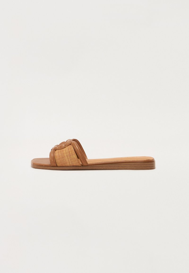 Sandały na slip-on s hnědou koženou podrážkou, tkaným páskem a texturovaným detailem. Plochá podrážka s minimalistickým designem.