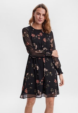 Black dress with floral print in pink and green. Sheer long sleeves with gathered cuffs, and a flared skirt design. Soft fabric texture.