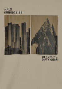 Beige grafisk t-shirt med två svartbruna bilder: en stads silhuett till vänster och en bergskedja till höger. Texten lyder "HALO 196819721981" och "OFF DUTY GEAR."