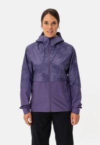 Lila leichte Jacke mit Kapuze, die eine glatte Textur und ein zweifarbiges Design aufweist. Logo und Reißverschlussdetails sind auf der Vorderseite sichtbar.