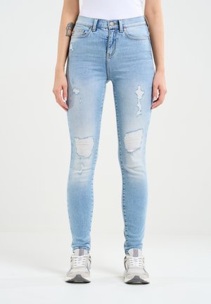Hubené světle modré džíny s vybledlými detaily a třaslavými záplatami, klasický pětipocket design. Materiál vypadá jako denim.