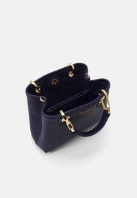 Námořnická modrá kabelka z texturované kůže se zlatými detaily, dvojitými uchy a dvěma vnitřními přihrádkami. Strukturovaný tvar s zacvakávacím uzávěrem.