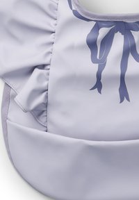 Ljuslila tygväska med en slät textur, med rynkade kanter och en glänsande blå rosettdesign i mitten.