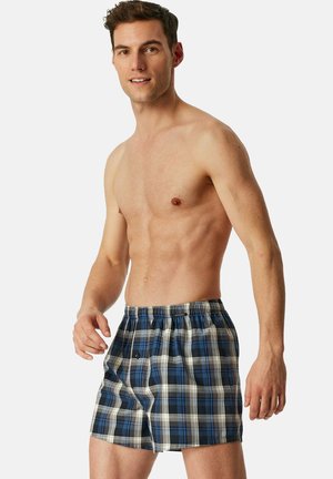 Boxers à carreaux bleus et blancs avec une ceinture élastique, dotés d'un bouton sur le devant et fabriqués dans un tissu léger et respirant.
