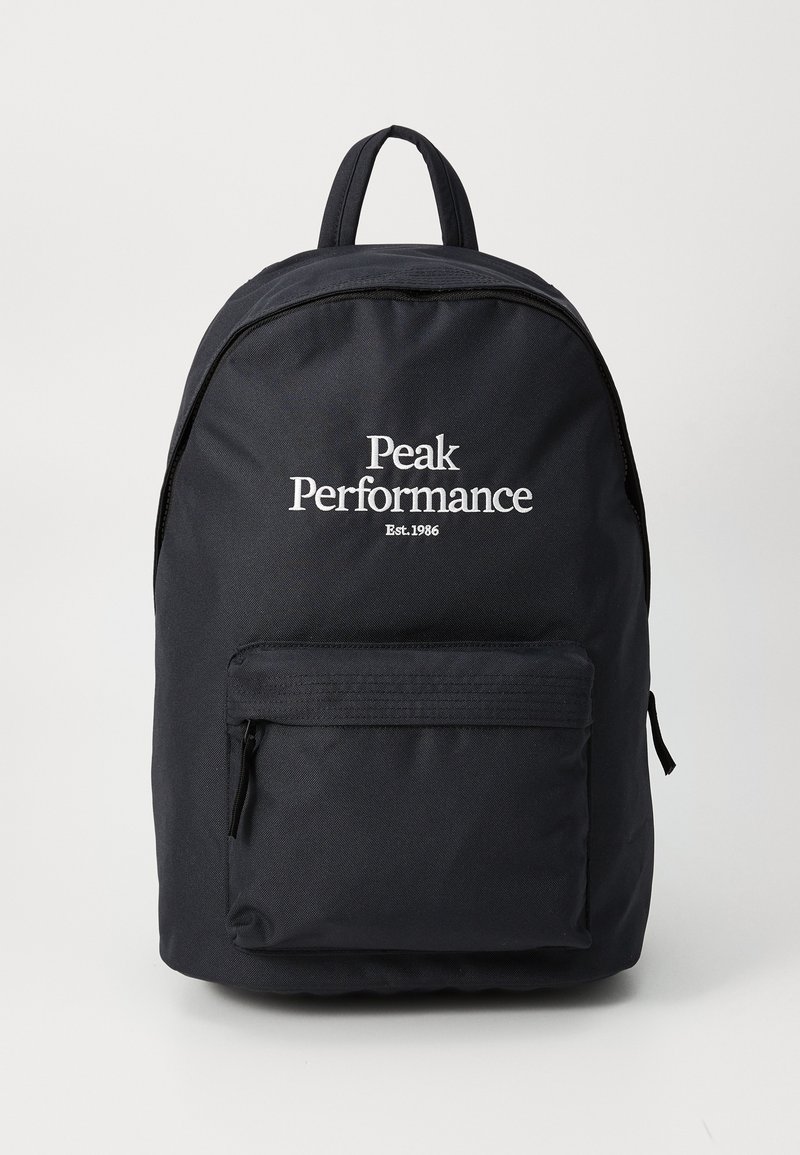 Black backpack with front zipper pocket, top handle, and white "Peak Performance Est. 1986" logo centered on the upper front panel.