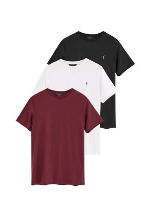 Tres camisetas de manga corta con cuello redondo en negro, blanco y rojo oscuro, cada una con un pequeño logo de jugador de polo en el pecho izquierdo.