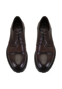 Bruine leren schoenen met een ronde neus, voorzien van een vetersluiting, gestructureerde accenten en een gladde afwerking op het bovenwerk. Zwarte rubberen zool.