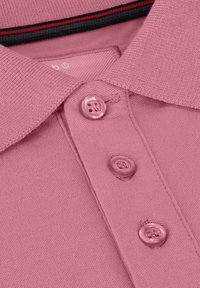 Roze polo shirt met een geribbelde kraag met zwarte en rode accenten, drie knopen en een gegerande katoenen afwerking.