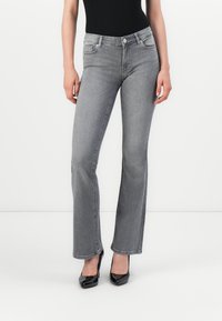 Grå denim flared jeans med mid-rise liv, som har et klassisk femlommersdesign, subtil falming og en glidelås med knappelukking.