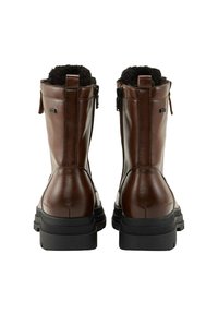 Bottes en cuir marron avec une finition texturée, fermeture éclair et doublure en fourrure noire rembourrée. Semelle en caoutchouc épaisse offrant une bonne adhérence.