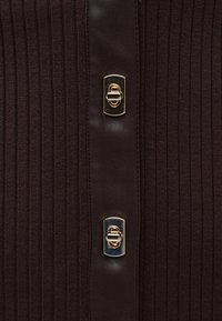 Σκούρο καφέ υφασμάτινο με ραβδώσεις και λείο κάθετο λωρίδα με δύο χρυσούς ορθογώνιους κλειδαριές τύπου turn-lock.