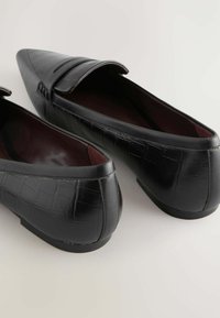 Schwarze Lederloafers mit einem strukturierten Krokodilmuster, spitzer Zehe und niedrigem Absatz. Verfügt über einen runden Schaft mit einer gestickten Akzentuierung.