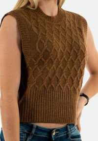 Jersey sin mangas de color marrón con un patrón de trenzas y ribete acanalado. Fabricado en material texturizado, con un cuello alto y un ajuste ceñido.