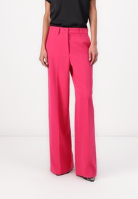 Roze wijde broek met een zachte textuur, voorzien van een knoop- en ritssluiting, zijzakken en een op maat gemaakt ontwerp.