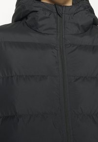 Černá prošívaná bunda s kapucí, s plným předním zipem, prošívanou texturou a hladkým materiálem. Žádné viditelné logo nebo vzory.