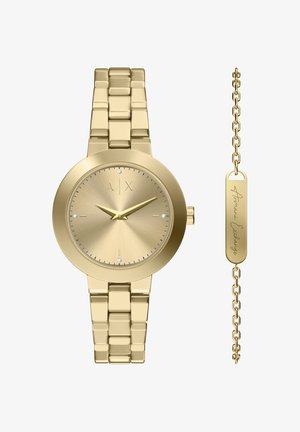 Goudkleurig horloge met een ronde kast, geborstelde wijzerplaat, drie edelstenen en een schakelband. Inclusief een gouden accentketting met gravure.