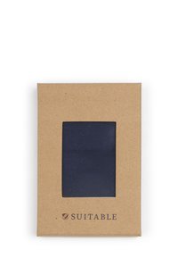 Marine stoffen stropdas weergegeven in een transparant venster, verpakt in een gestructureerde bruine kartonnen doos. "SLAAT" logo aan de voorkant.