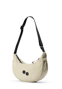 Beige Nylon Umhängetasche mit einer halbkreisförmigen Form, schwarzem Träger und zwei schwarzen runden Akzenten auf der Vorderseite. Verfügt über einen verstellbaren Träger.